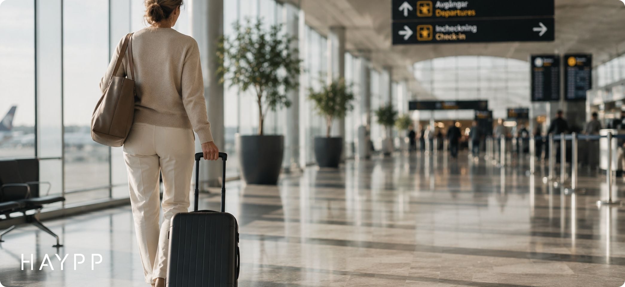 Kvinna som går med sitt bagage på arlanda